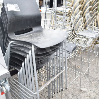 Stack of 12 modern chairs, including black chairs with chrome legs and wire chairs. Slightly worn condition.