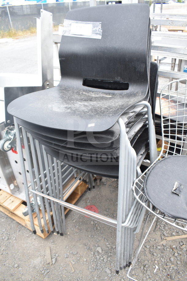 Stacked black chairs with chrome legs and a wire chair, sold in a lot of 12. Slight wear visible.