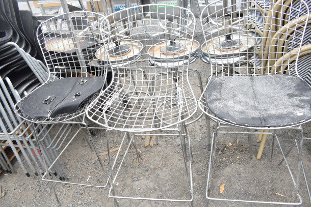 12 wire chairs with chrome finish legs, some with black cushions. Mixed used condition. Auction lot includes 12 items.