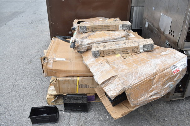 Cardboard boxes containing 12 new scratch-and-dent items, including a shelf and filler table, show visible packaging wear.