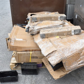 Cardboard boxes containing 12 new scratch-and-dent items, including a shelf and filler table, show visible packaging wear.