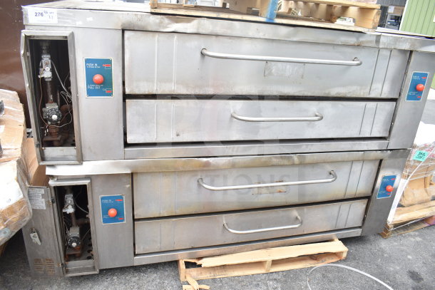 Two commercial gas-powered single deck pizza ovens, stainless steel, front control panels, used condition, visible wear.