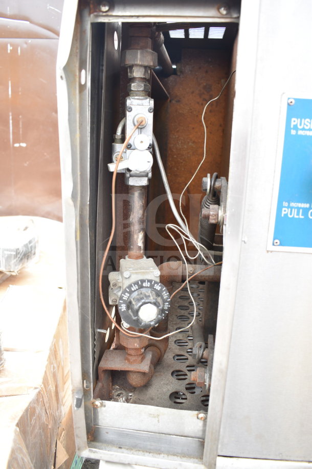 Commercial gas-powered single deck pizza oven interior showing control knob and gas piping, in used condition.