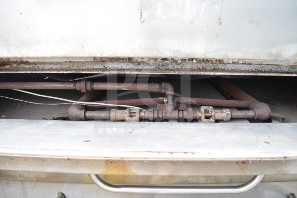 Commercial gas-powered single deck pizza oven, showing interior gas pipes. Well-worn condition, visible rust and wear.