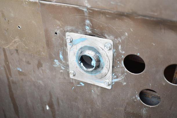 Alt Text: Close-up of a commercial gas-powered pizza oven's metal exterior. Surface shows wear and paint marks.