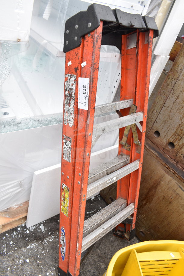 Werner A-frame ladder, orange, metal steps, visible wear, product ID tag attached.