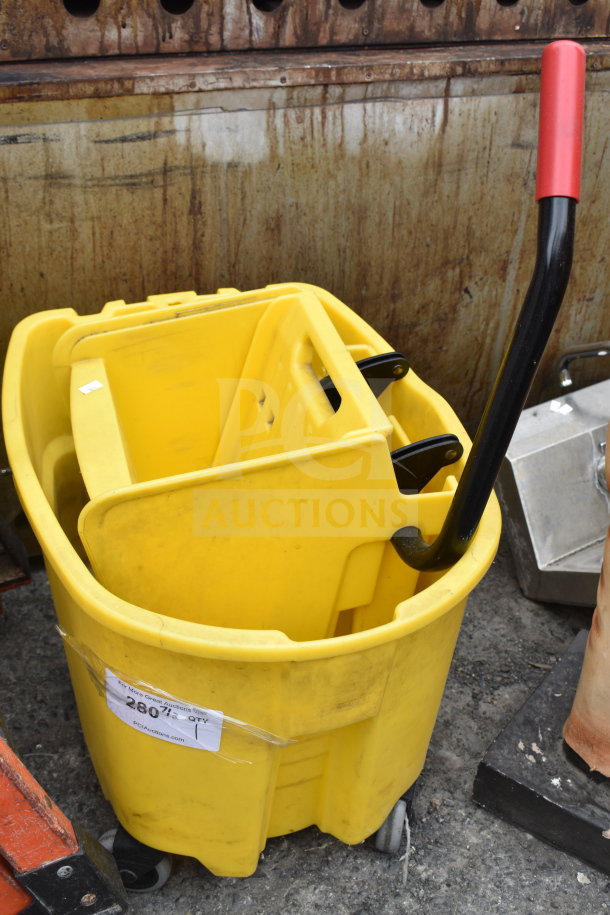 Yellow poly mop bucket with wringing attachment, features metal handle with red grip, on wheels; auction tag visible.
