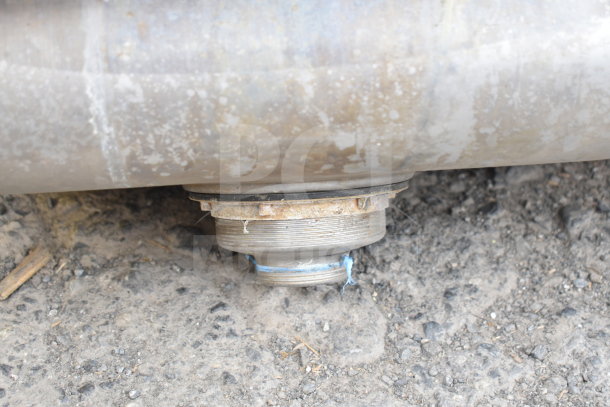 Commercial single bay wall mount sink underside, showing metal drain fitting and signs of wear.