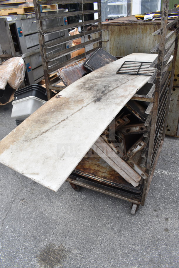 Commercial pan transport rack on casters, metal frame, visible wear and rust, stacking slots, ideal for kitchen use.