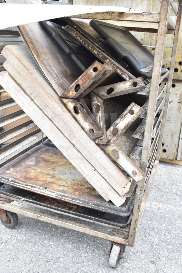 Commercial pan transport rack on casters, weathered metal, holds trays vertically, visible rust, sturdy design.