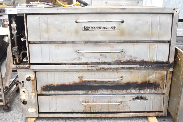 2 Bakers Pride commercial single-deck pizza ovens, natural gas powered, worn condition, with visible branding and controls.