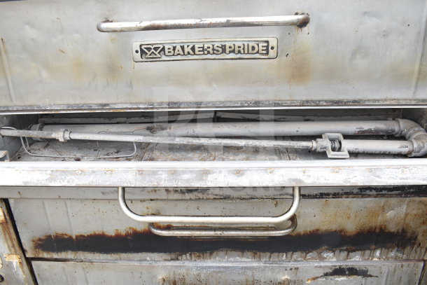Bakers Pride commercial natural gas single deck pizza oven, rustic condition, featuring logo plate, metallic handles, and visible piping.