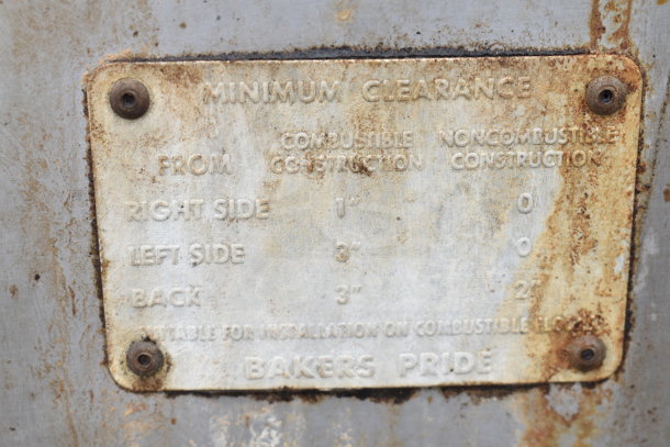 Rusty Bakers Pride pizza oven metal tag showing minimum clearance instructions.