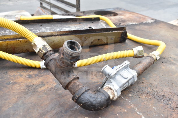 Bakers Pride commercial pizza oven connections with gas hoses and fittings, slightly rusted, natural gas compatible.