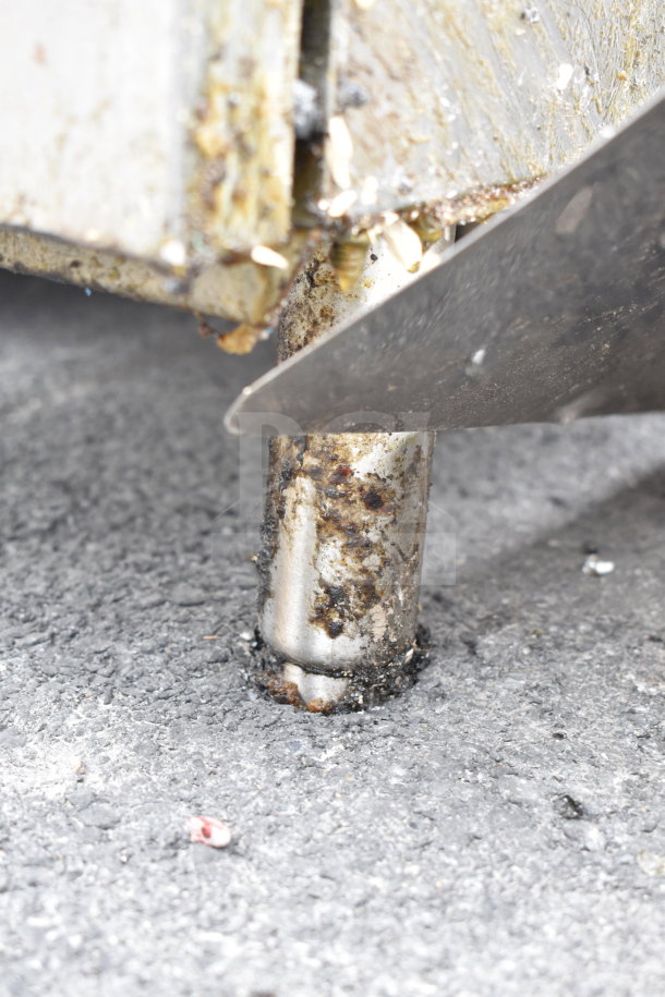 Commercial gas-powered floor-style deep fat fryer in used condition, showing grease and wear on the metal exterior.