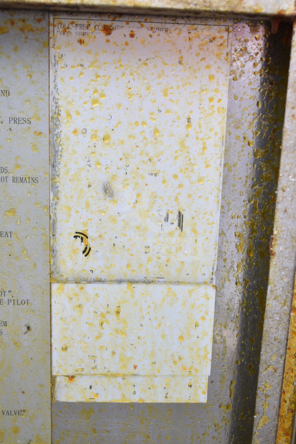 Commercial gas-powered deep fat fryer in used condition, showing surface grime and stains. Indistinct labeling.