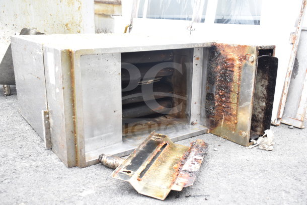 Commercial gas-powered deep fat fryer, floor style, showing signs of heavy use and rust, open interior visible.