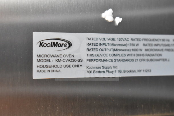 KoolMore KM-CWO30-SS label detailing model, voltage, and compliance information on stainless steel surface.