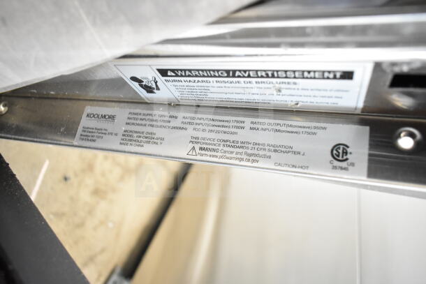 KoolMore KM-CWO24-AFSS label detail, 120V, 1.6 cu. ft., highlighting warnings and specifications. Glass damage noted.