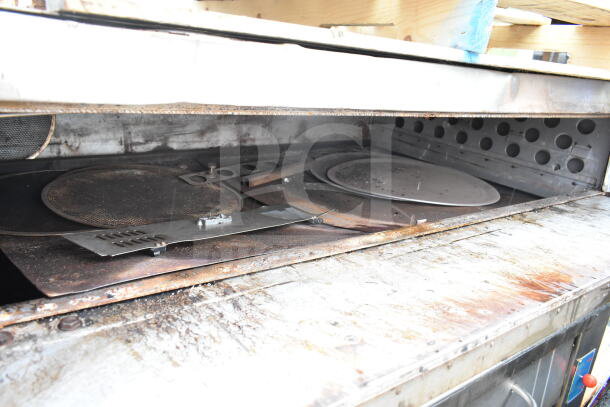 Commercial gas-powered single deck pizza oven, used condition, with metallic interior and baking racks visible.