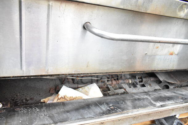 Commercial gas-powered single deck pizza oven with metal finish, visible wear and interior components, used condition.