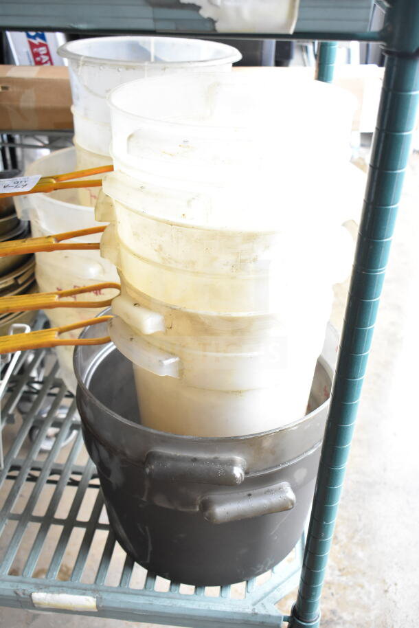 Lot of various kitchen items including fry baskets, plastic containers, and metal bowls on a shelf. Some wear visible.