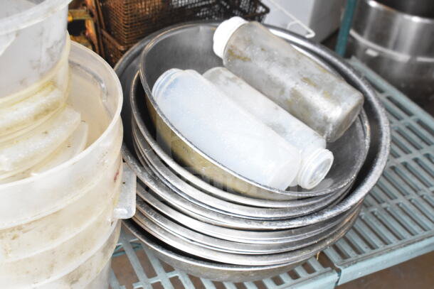 Lot of kitchen items including fry baskets, metal bowls, and plastic squeeze bottles; showing used condition.