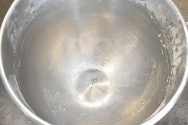 Stainless steel mixing bowl for Hobart mixer, shows wear, ideal for professional kitchens. Includes dough hook attachment.