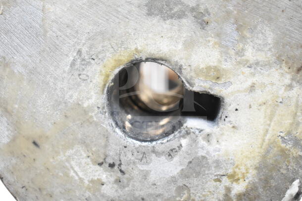 Close-up of a stainless steel surface with visible textures and markings. Condition appears used.