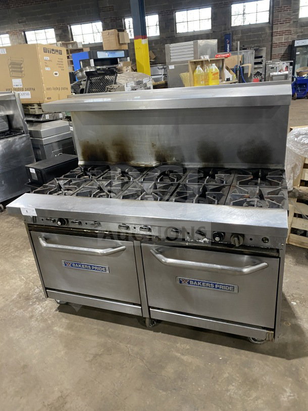 Bakers Pride stainless steel gas range with 10 burners, double oven, model 955394604036. Features backsplash, salamander shelf, oven racks, and casters.