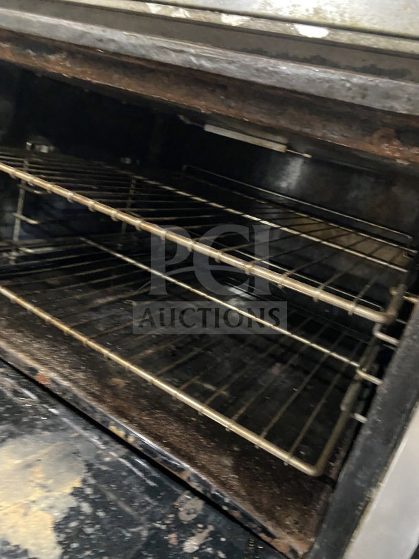 Bakers Pride stainless steel double oven with wired racks, model 955394604036, used condition, interior view.