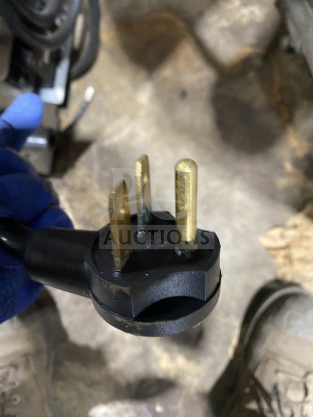 Close-up of a power plug for a MerryChef Eikon E2S high-speed cook oven. Three-prong, black casing, visible wear.