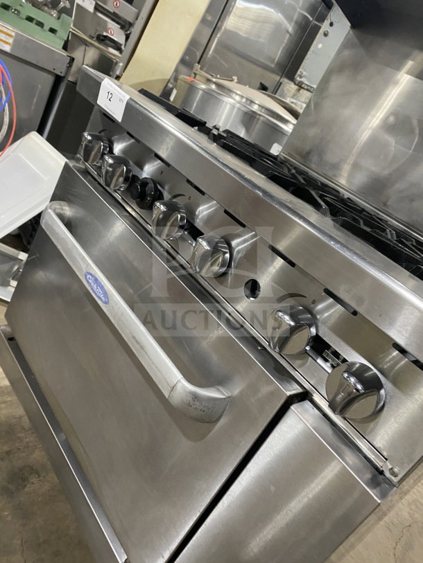 CookRite commercial stainless steel gas 6-burner range/oven combo with backsplash, salamander shelf, and wired oven rack on casters.