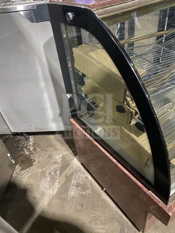 Leader Commercial 48" curved glass bakery display case, Model EMCB48D. Non-refrigerated, sturdy metal shelves. Good condition.