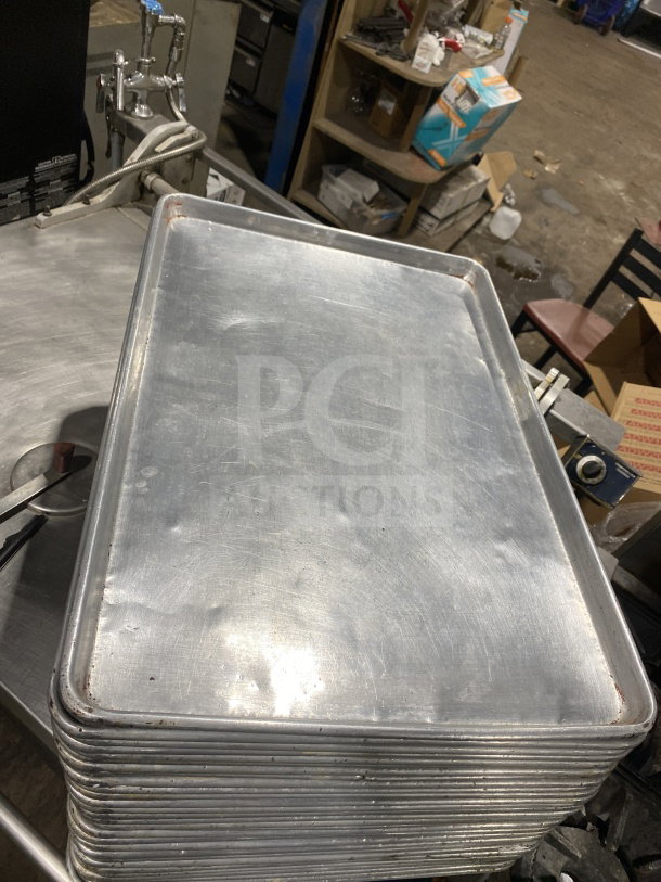 Commercial stainless steel full-size baking sheet pan, lightly used, stack of several pans, durable construction, ideal for high-capacity baking.