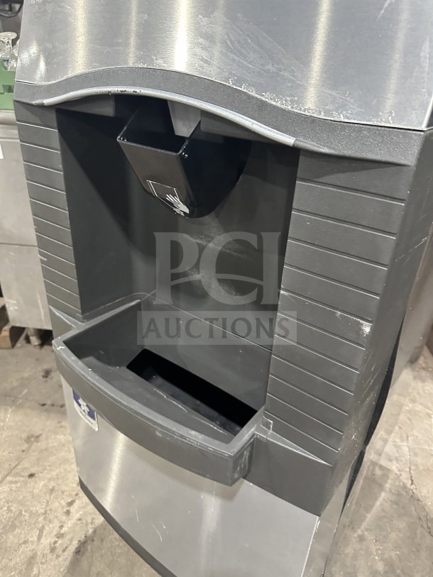 Manitowoc stainless steel ice machine with ice bin, model SPA310, 115V, 1 phase, on legs, visible wear.