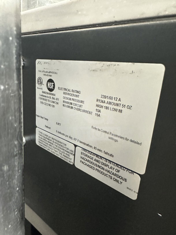 Commercial electric refrigerated open-air display merchandiser, 220V, 1 phase. Label shows electrical rating and refrigerant type.