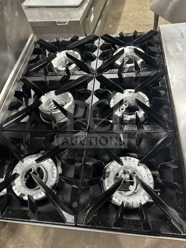 Vulcan commercial stainless steel 6-burner gas range/oven with backsplash and wired oven rack. Features casters for mobility.
