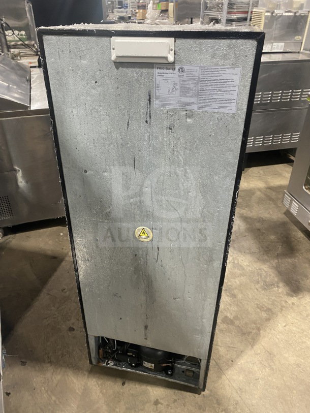 Frigidaire commercial stainless steel upright freezer, model EFRF694, with poly coated wired rack. 115V power. Visible tags and labels show model and safety instructions.