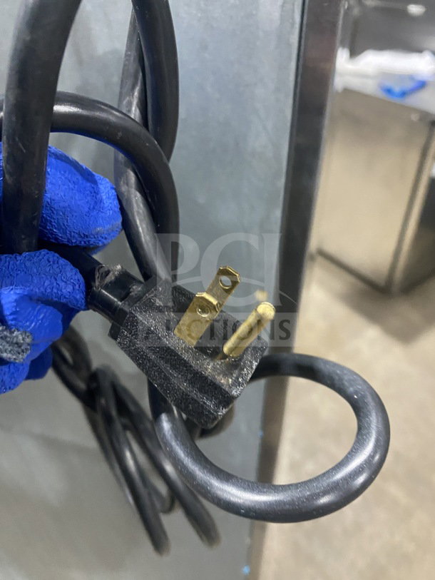 Hoshizaki CF1B-FSL commercial freezer plug, 115V, 1 phase, coiled cable, gloved hand holding.