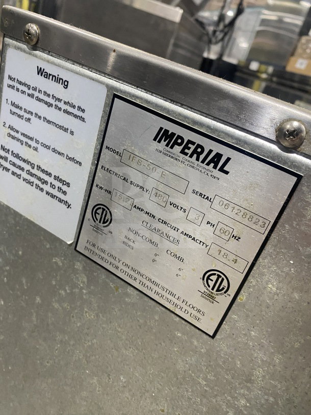 Imperial IFS-50-E commercial stainless steel electric deep fryer, full pot with fry basket, splash back, on casters. Model and serial tags visible.