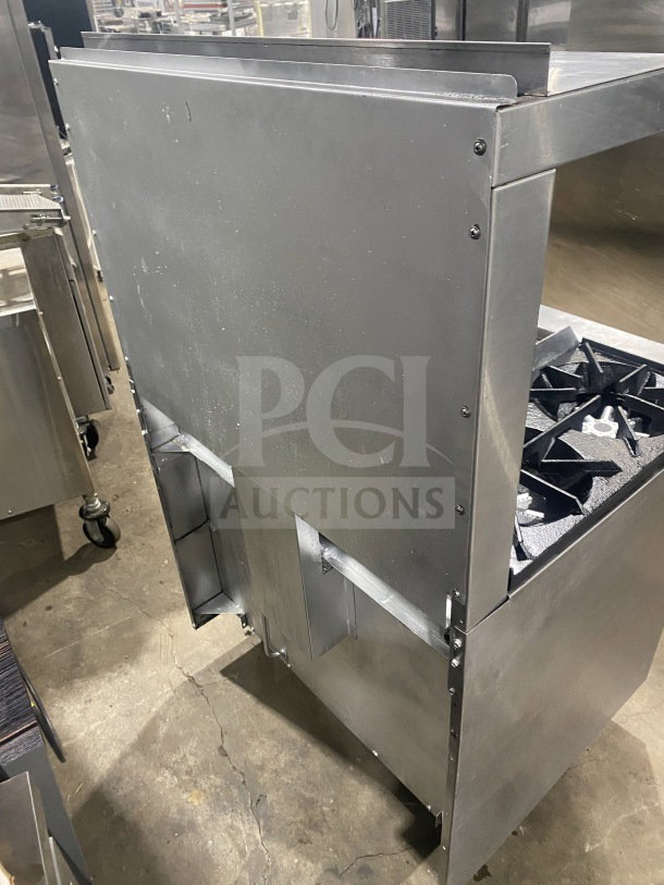 Commercial stainless steel 2-burner gas range with plancha grill, convection oven, wired rack, and splash back, in good condition.