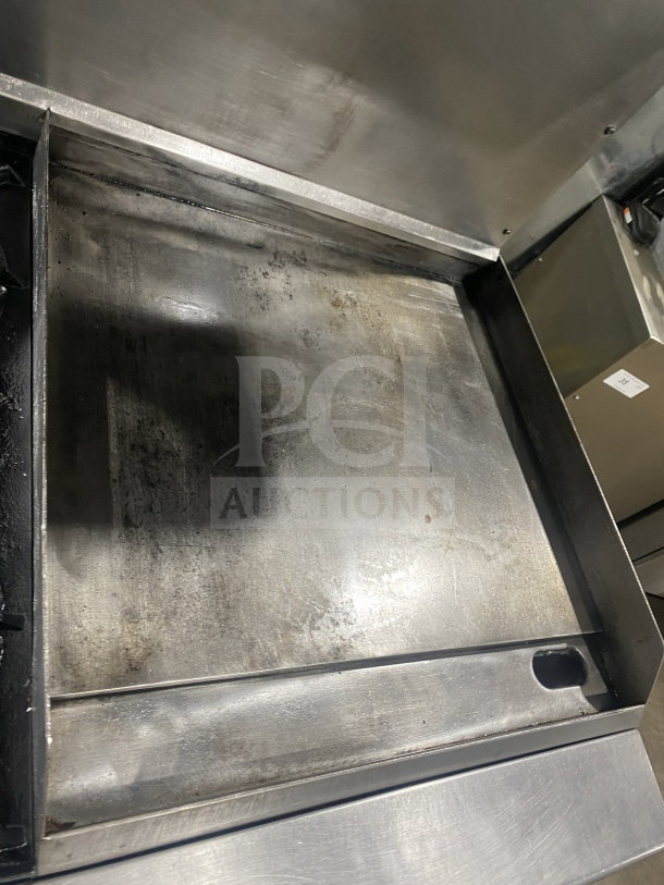 Commercial stainless steel gas range with 2 burners, plancha grill, convection oven, and splash back. Includes wired oven rack.