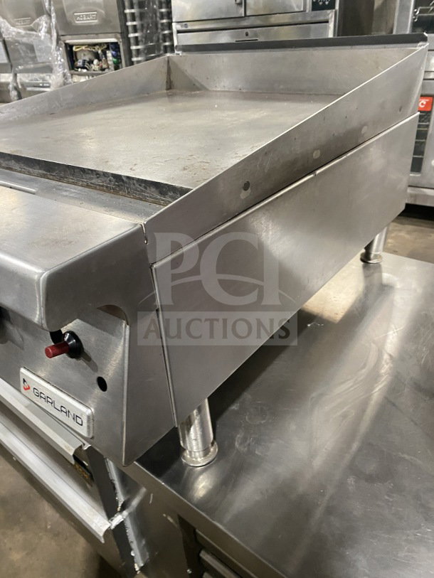 Garland G1GG24-G24 stainless steel gas griddle, heavy-duty, with back and side splash, on legs, model G1GG24-G24.