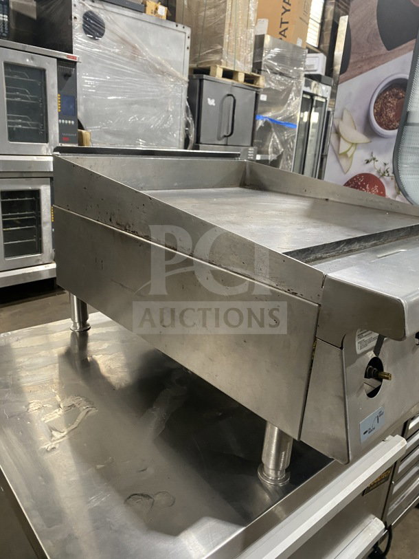 Garland G1GG24-G24 stainless steel natural gas griddle with back and side splash, on legs, in used condition.