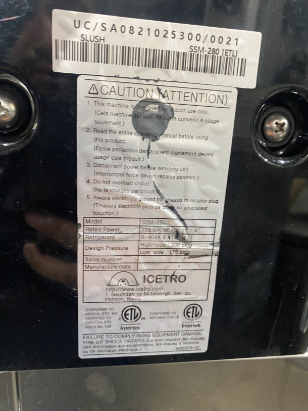 Icetro SSM280 stainless steel slushy machine label. Shows model, voltage (115V), refrigerant R-404A, and safety warnings.