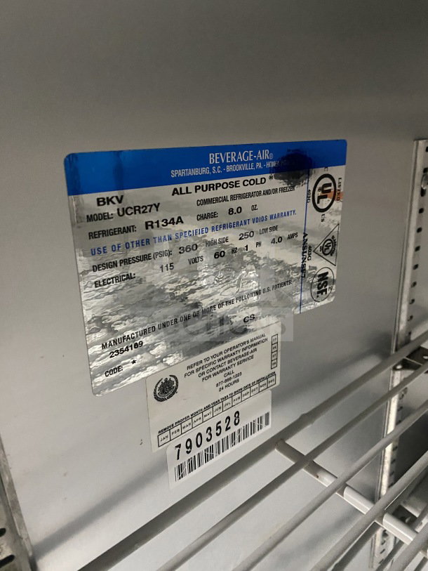 Beverage-Air UCR27Y stainless steel undercounter refrigerator, single door, model label visible, poly coated wire rack, on casters.