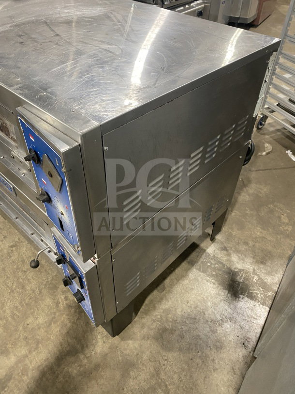 Bakers Pride commercial stainless steel double deck pizza oven on casters; electric powered, blue control panel, on legs.