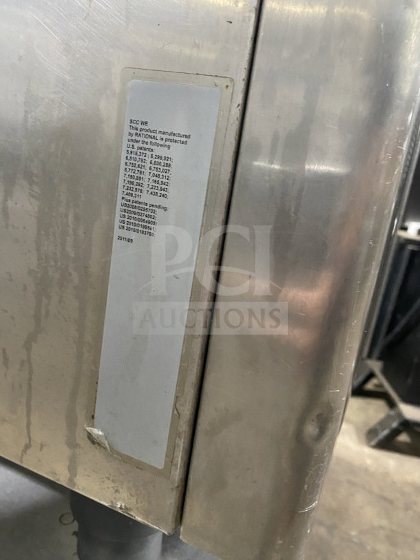 Rational oven with efficiency series label, visible patent numbers, and metal surface on legs. Includes pan-holding stand.