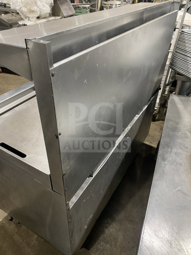 Southbend commercial stainless steel range, 6 burners, 24" flat griddle, 2 full-size ovens underneath, on casters.